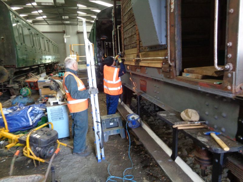 Patrick Doyle trimming bolts with the angle grinder whilst John Davis waits patiently with ladder ready to apply filler to the woodwork.brPhotographer David BellbrDate taken 10102019