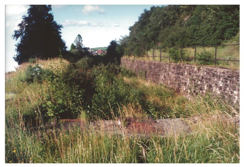 The loading dock of the Okehampton military sidings. The line climbs towards Meldon above the wall on the right.brPhotographer Colin BurgesbrDate taken 08081991