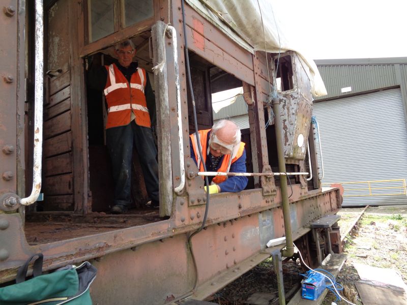 Patrick Doyle grinding out rusted-in bolts in the SR brakevan LDS55625, with John Davis pausing from stripping out decayed interior woodwork.brPhotographer David BellbrDate taken 01062017