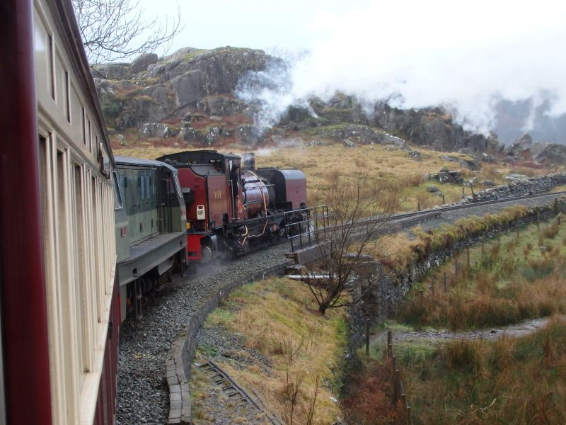 Welsh Highland Garratt no. 138 leading Ffestiniog Railway Funkey diesel 'Vale of Ffestiniog' round Fridd Isaf curve.brPhotographer Tom BaxterbrDate taken 23122017