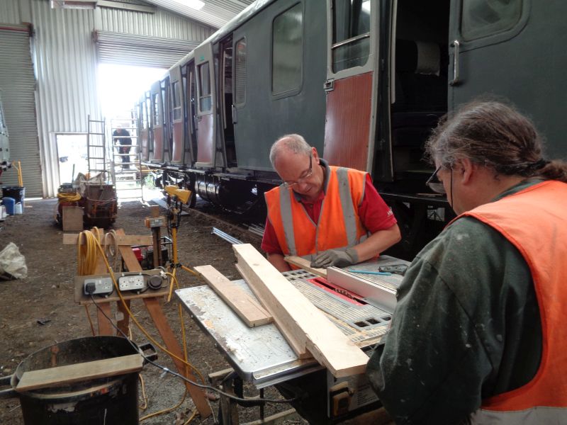 A tricky bit of rebating for a bottom sill to the brake van side, using the flat-bed saw. The ever present John Coxon is in the background erecting the staging in readiness for the door painting phase.brPhotographer David BellbrDate taken 02082018