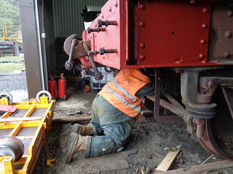 Scraping off accumulated dirt, old grease and rust from the brake piping at one end of the SR brake van. Not for the squeamish Once the buffers are refitted the next heavy lift task will be to replace the 8 perished rubber sandwiched dampers attached to the springs one of which can be seen.brPhotographer David BellbrDate taken 20092018