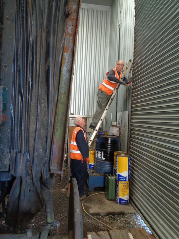CW versus the elements. Ron Kirby fixing the door with even larger screws Geoff Horner holding ladder whilst supervising.brPhotographer David BellbrDate taken 18102018