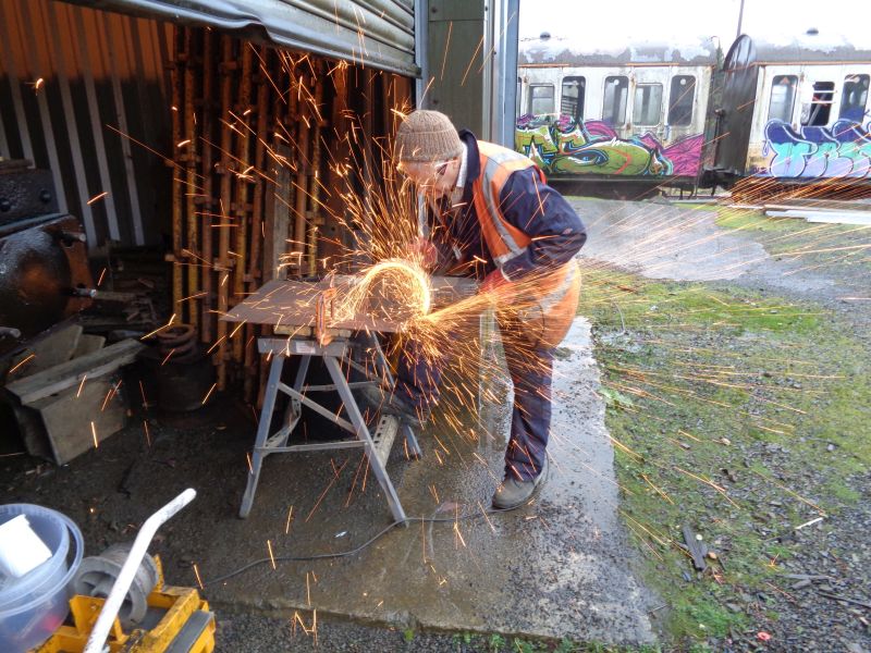 Cutting out steel plates for the spacer on the damaged buffer. Note the insidious graffiti in the backgroundbrPhotographer David BellbrDate taken 06122018