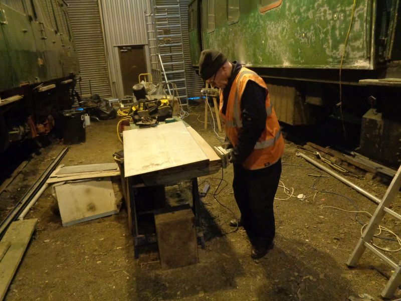 Ron Kirby sanding the plywood skin the guard's door. The aluminium cladding lying nearby having been tried for a good fit.brPhotographer David BellbrDate taken 10012019