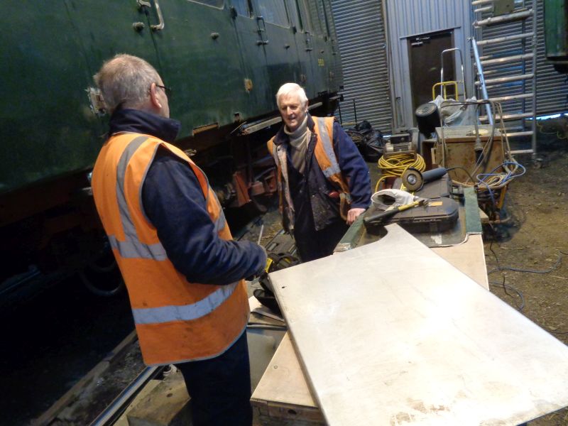 Ron Kirby discusses the next step with John Coxon, having cut the replacement outer skin for the the Guard's door to shape with the angle grinder.brPhotographer David BellbrDate taken 17012019