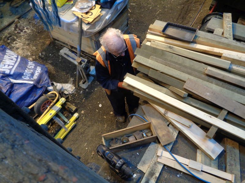 Geoff Horner, using an electric wire brush, below a stack of off-cuts and the few remaining planks left for refurbishing the brake van. Other builder's merchants are available.brPhotographer David BellbrDate taken 14032019