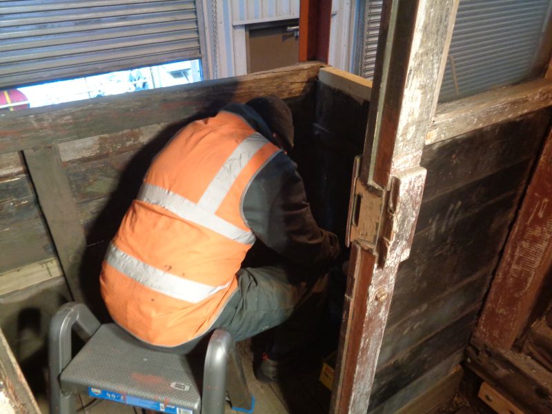 John Davis scraping off old paint on the Eastern veranda of the brake van.brPhotographer David BellbrDate taken 14032019