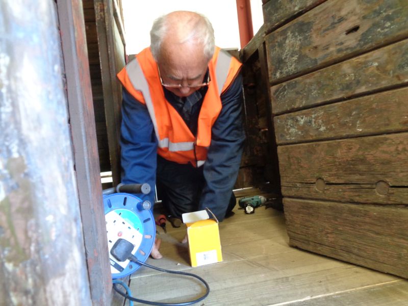 Patrick Doyle screwing down floor boards in the Eastern veranda of brake van LDS55625.brPhotographer David BellbrDate taken 28032019