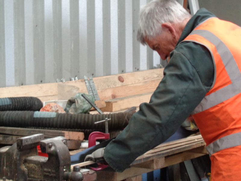 Cutting wood for trimming the interior of the brake van cabin. John Davis with large saw. Note the new brake pipe couplings waiting to be fitted on SR brake van LDS55625.brPhotographer David BellbrDate taken 23052019