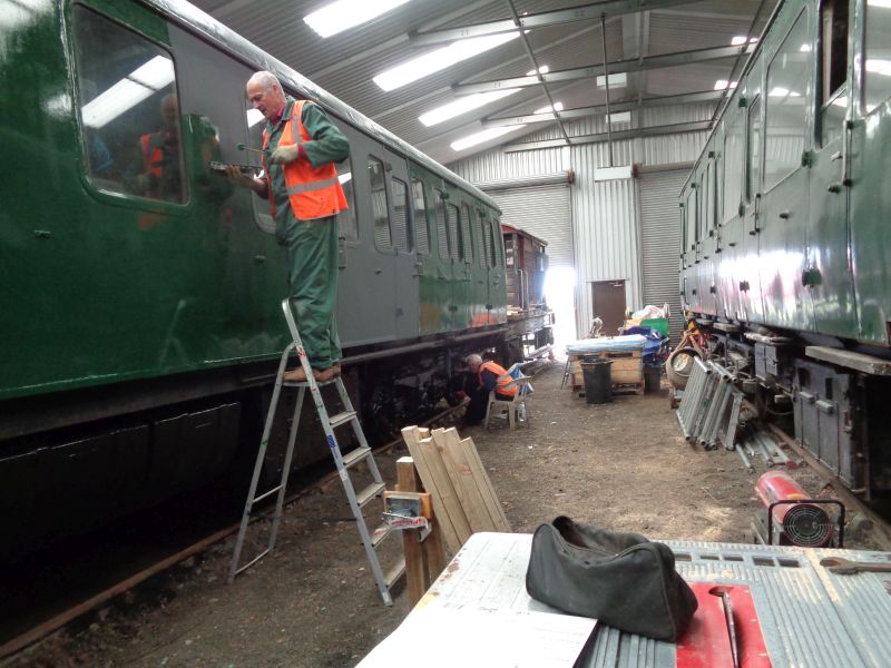 Nigel Green applies top coating to the Thumper whilst Geoff Horner, standing in as painting machine in Alan Harris's absence, paints the under-frame and running gear.brPhotographer David BellbrDate taken 20062019