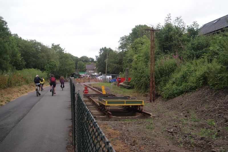 The Tarka Trail cycle and walking path, sharing the trackbed with the TVR. The former Torrington station - now the Puffing Billy restaurant - is in the background.brPhotographer Jon KelseybrDate taken 13072019