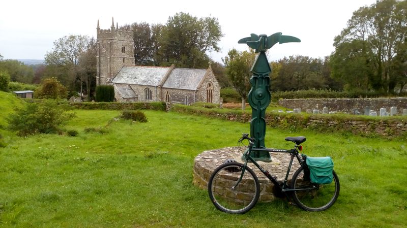 The 14th Century church of St Thomas a Becket at Sourton, and one of the distinctive National Cycle Network signposts. The enterprising church was serving cream teas and sandwiches on Sunday afternoons in August.brPhotographer Jon KelseybrDate taken 25082019