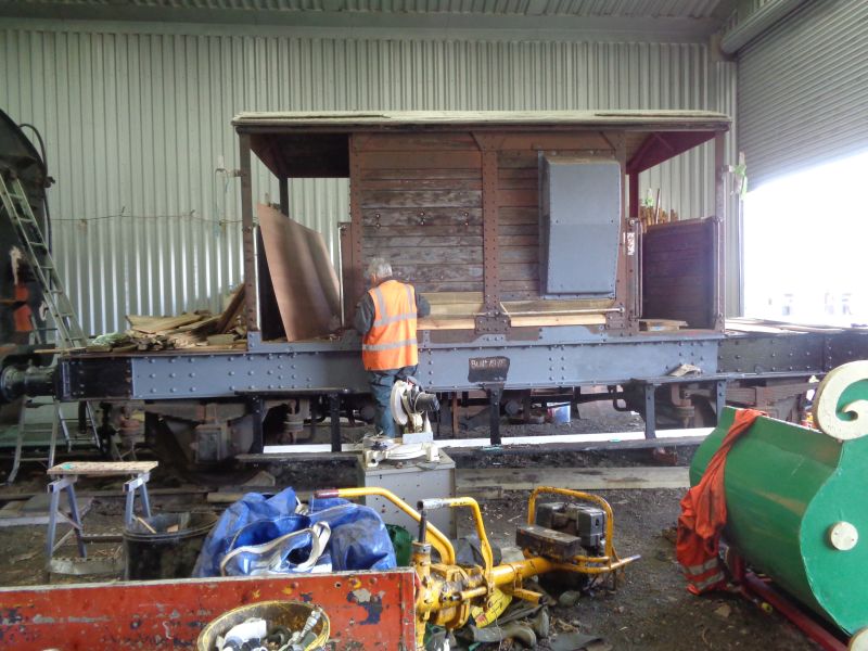 Bolting-on the last two pieces of the jigsaw puzzle on the North side of brake van LDS55625 by John Davis. Seen from across a jumble of DRCIC equipment. An original Ashford identification underframe marking uncovered today revealed that it was originally plain 'S55625'.brPhotographer David BellbrDate taken 12092019