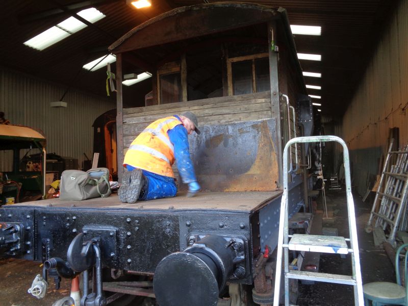 Alan Harris, having completed work over at the visitor's site and some colourful painting on the Thumper power car, cleans up the Eastern platform of the SR brake van. Note the stove's steel back plate waiting to be installed and the competed priming of the North side mainframe.brPhotographer David BellbrDate taken 07112019