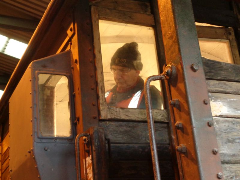 John Davis basks in the warm glow of the floodlighting whilst painting inside the brake van cabin. Note door ajar to allow cold fresh air circulation - in moderation.brPhotographer David BellbrDate taken 28112019