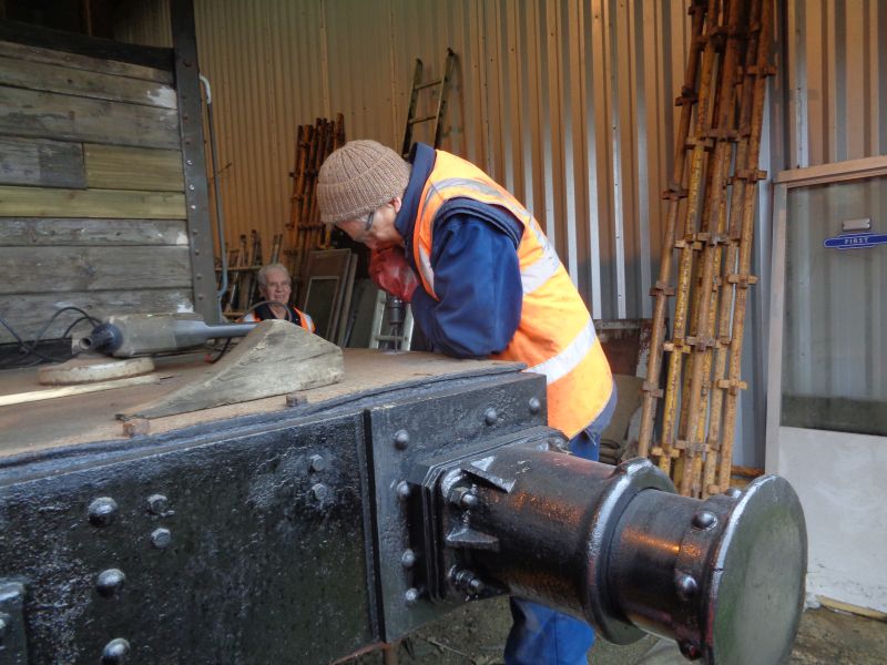 Drilling out the edges of the countersunk bolt heads. Patrick assisted, between bouts of rubbing down woodwork filler, whilst Geoff watches with interest.brPhotographer David BellbrDate taken 05032020