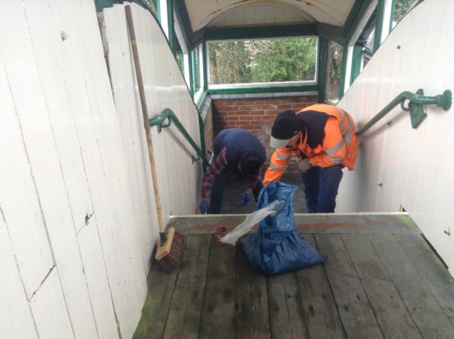 The Station Maintenance Team at work applying a non-slip surface to the Okehampton Station footbridge.brPhotographer Tony HillbrDate taken 09122020