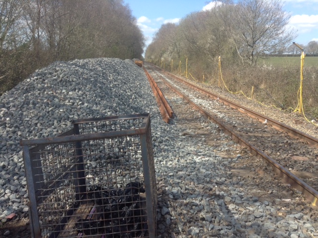 Looking west, the track here was laid in 1959 and alongside lies the new continuously welded rail made at Scunthorpe steelworks together with some ballast that came by rail from Cliffe Quarry in Leicestershire, via Westbury one of the last remaining Freight and Engineering train marshalling yards on the former BR WR. Lineside generators power the temporary electric lighting erected along the line for several miles for night working.brPhotographer Tony HillbrDate taken 15042021