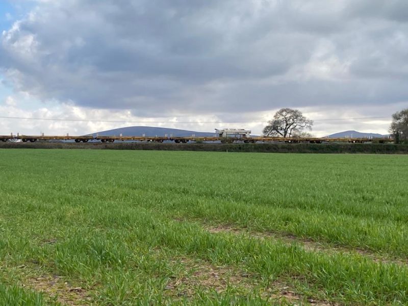 The Balfour Beatty New Track Construction train approaching North Tawton, with Dartmoor in the background.brPhotographer Tony HillbrDate taken 27042021