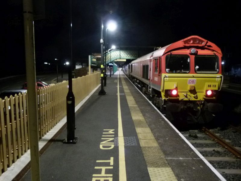 Class 66 66113 on the Plymouth end of a late evening railhead treatment train RHTT in Okehampton Station.brPhotographer Dave EllisbrDate taken 05102023