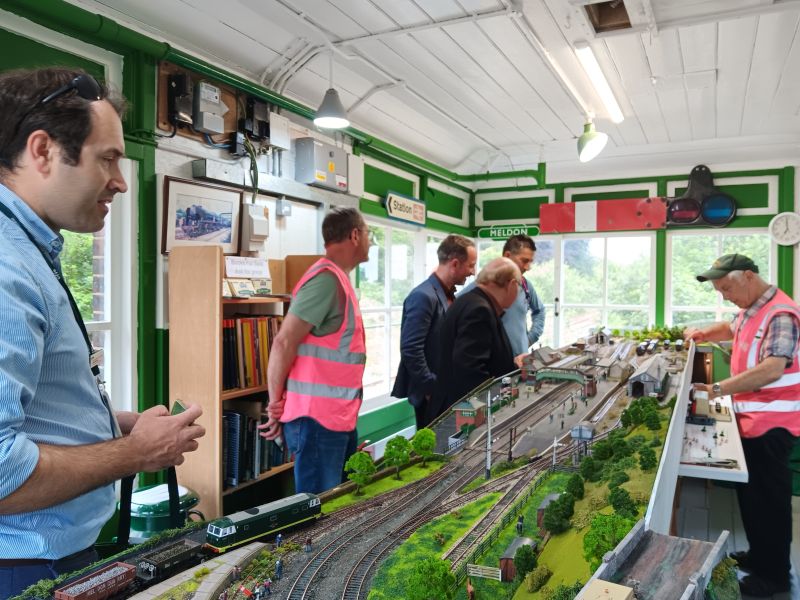 The visitors and the DRA welcoming party examining the model railway in Okehampton signalboxbrPhotographer Sue BaxterbrDate taken 18062026