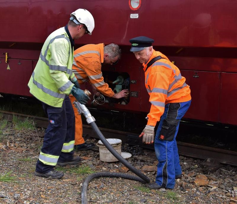 Tom Baxter (in 1956 Romanian Air Force surplus hat) helping to refuel the locomotive.