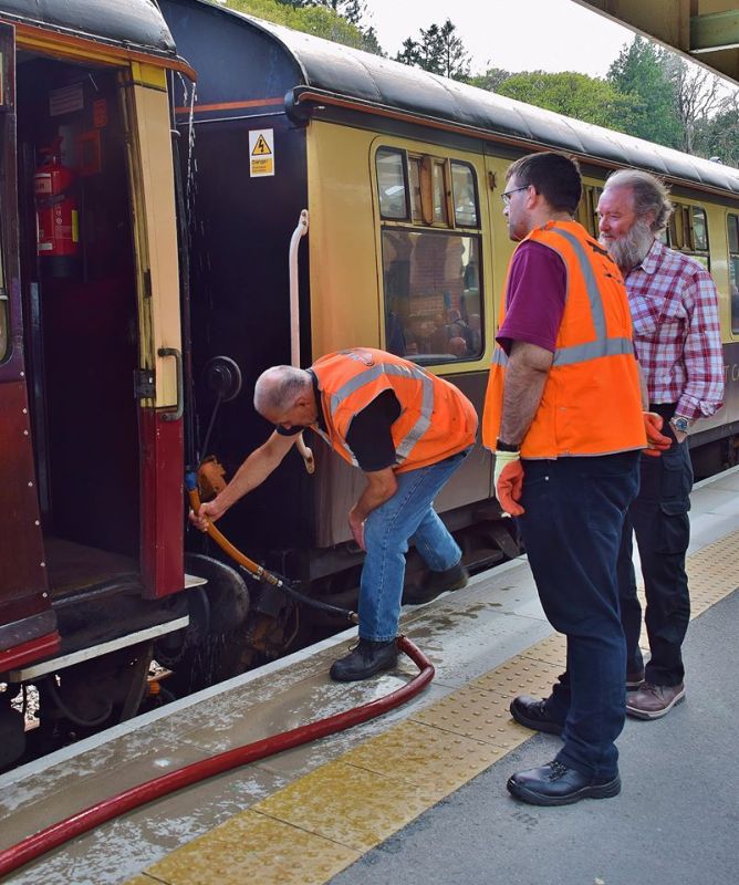 Geoff Brookes watering one of the railtour coaches, and doubtless getting some welcome advice from his audience.