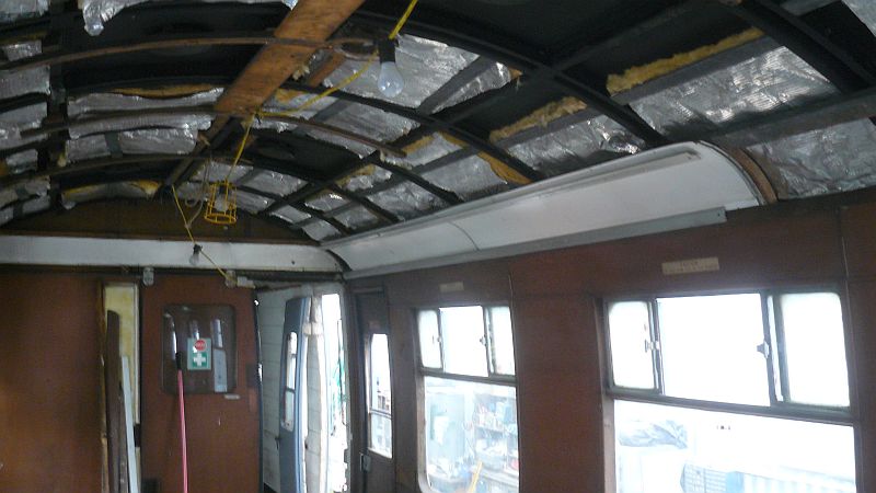 Showing the start that has been made on replacing the coach ceiling with the insulation pads in place and the first two side panels positioned.