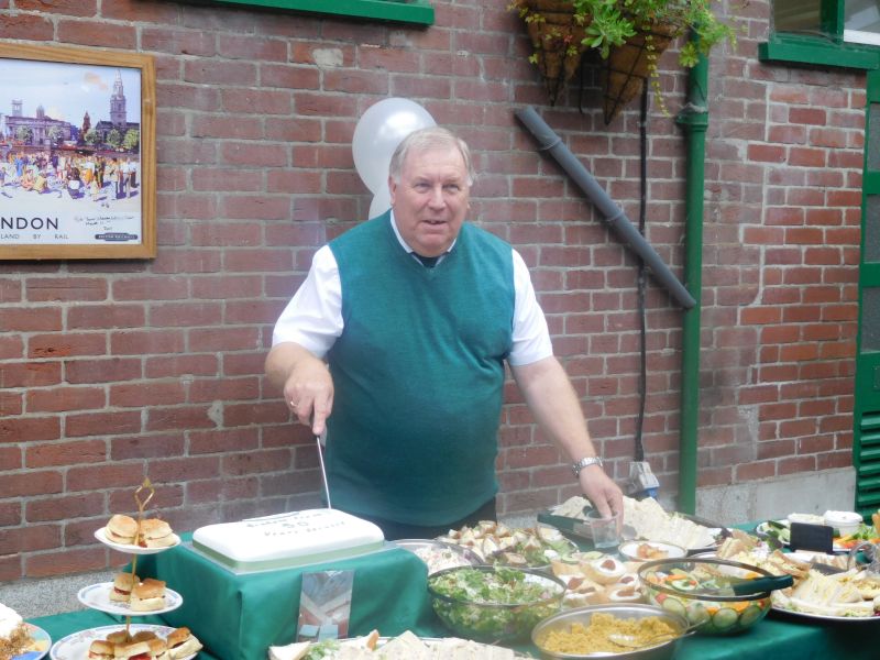 Graham cutting his cake. Note the typical Okehampton sumptuous spread.