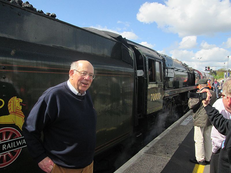 DRSA's magazine editor, ticket seller and station announcer Peter Ritchie, at Exeter St Davids in front of BR Class 7 Pacific Britannia, about to board the Great Britain 8 railtour.
