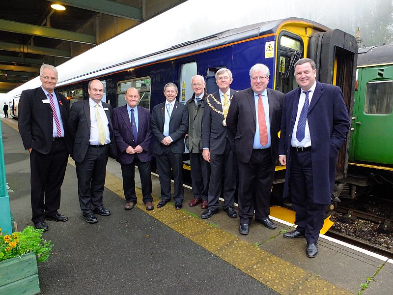The party at Okehampton station. l to r: Bruce Thompson (Head of Transportation service DCC); Mark Hopwood (Managing Director of FGW); Cllr Dr Michael Ireland (OTC, Chair of Destination Okehampton); Cllr Kevin Ball (DCC - Okehampton Rural, WDBC, OTC); Cllr John Clatworthy (DCC - Dawlish); Cllr Paul Vachon (Mayor of Okehampton); Patrick McLoughlin (MP, Secretary of State for Transport); Mel Stride (MP for Central Devon).