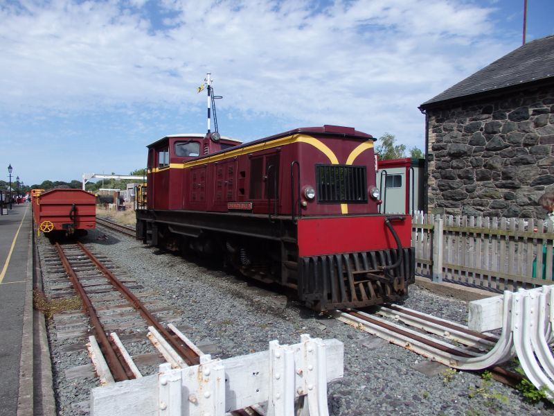 Welsh Highland Railway Funkey B-B Diesel 'Castell Caernarfon' in the yard at Dinas. The distant signal looking as if it's sprouting out of its roof (nice composition Tom!) is in fact the former up distant signal for Dinas LNWR station. Today's 'new' WHR station is on the site of the former standard gauge platforms and this signal has been erected in memory. 