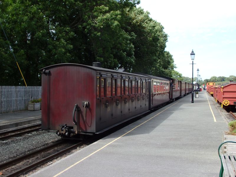 North Wales Narrow Gauge Railway replica carriage no. 24 at Dinas on the rear of the Welsh Highland Railway 14.05 Porthmadog to Caernarfon. NWNGR was one of the forerunner companies of the WHR. The coach was built in 2002 at Boston Lodge Works. It is a replica of of an 1894 'Ashbury' NWNGR 'Summer Coach'.